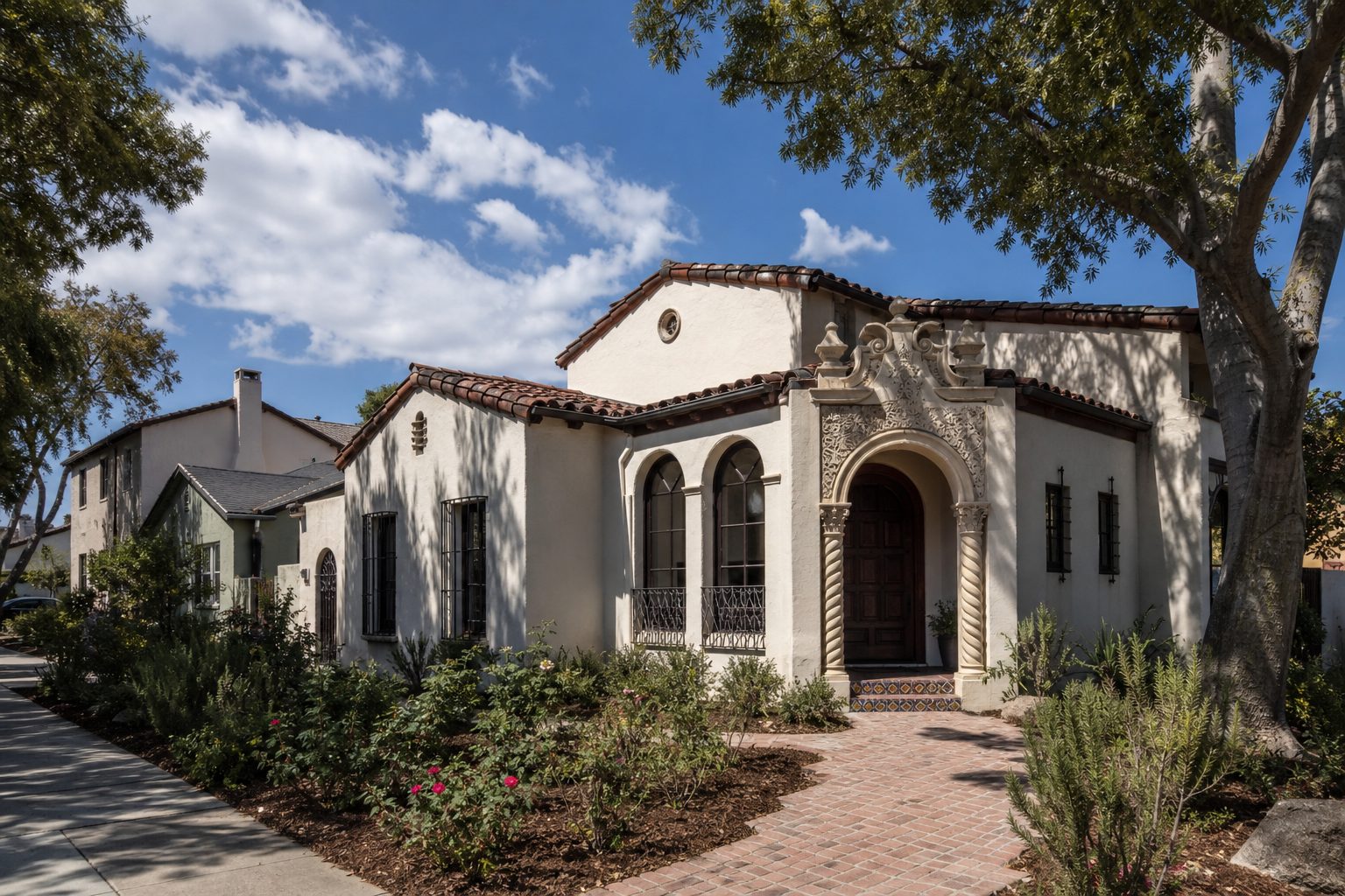 Spanish Colonial Revival home with arched entry and mature landscaping in North Park's historic Dryden district, San Diego.